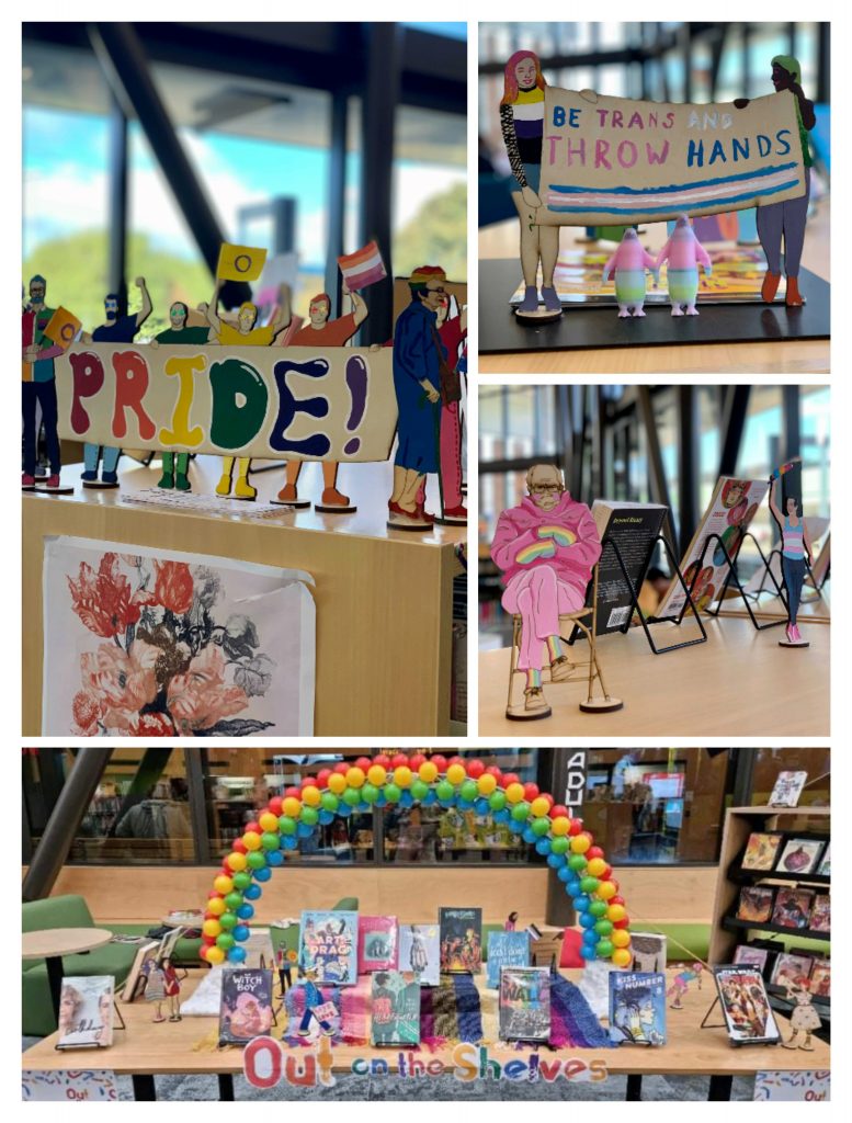 A collage of four pictures of the Johnsonville library display. Largest at the bottom is the whole display, a table covered with a selection of pride flag scarves, a sign across the from saying "Out on the Shelves”, rainbow-themed books on stands, then a large rainbow arch across the whole table. The second picture is a close-up of a group of colourful painted wooden figures holding a sign that says “Pride!”. The third picture is of two small wooden people holding a sign that says “Be Trans and throw hands” above two 3D printed penguins that are holding hands. The last picture is of a small wooden Bernie Sanders sitting on a chair in his famous mittens and mask pose. He is wearing all pink, except for his mittens and socks which are rainbow.