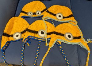 Five crochet beanies, designed to look like Minions