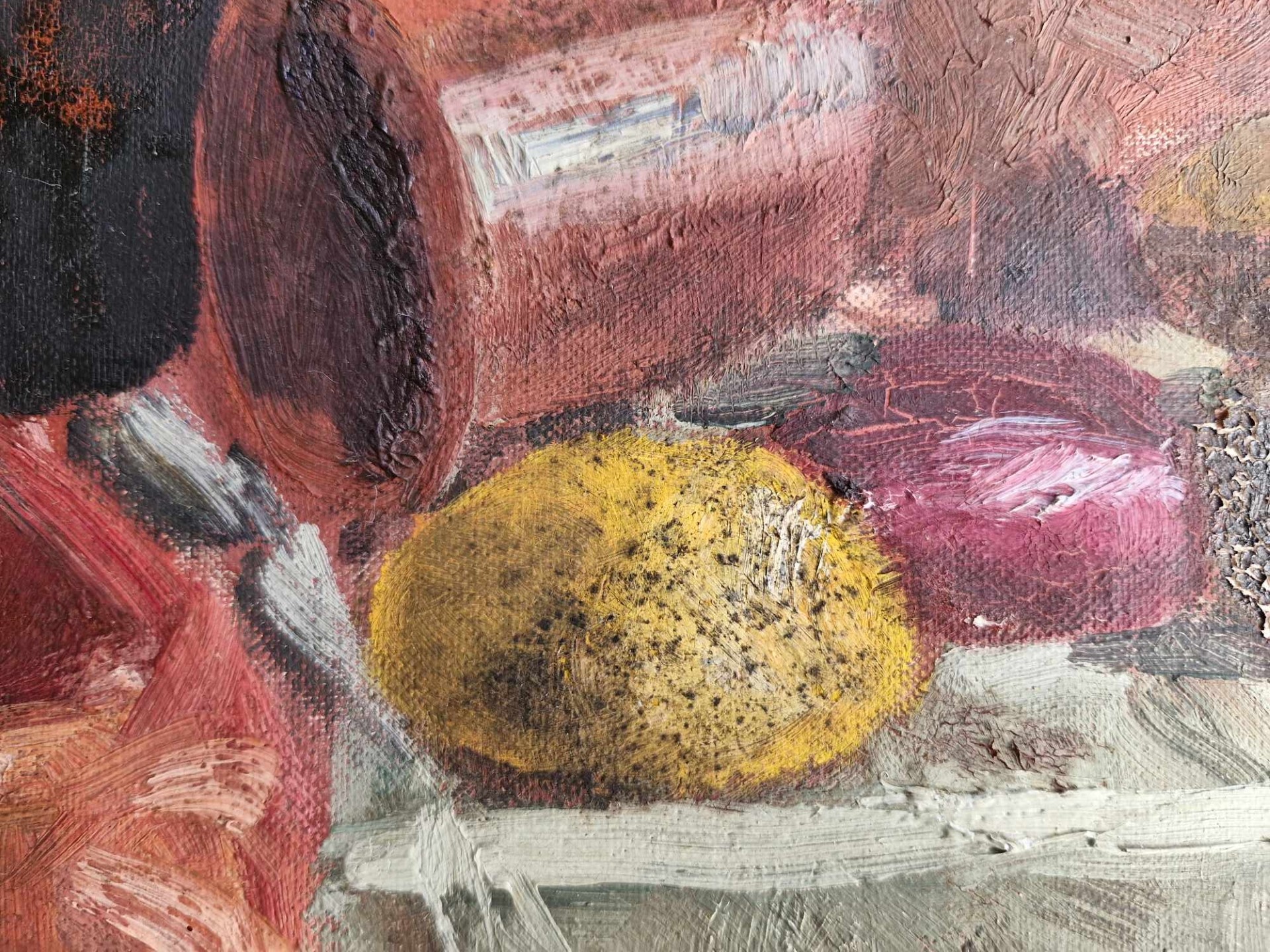 A close up of a painted lemon, marked with spots of black mould.