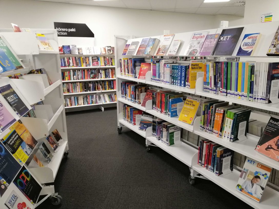 Two sets of whaite shelves facing each other, displaying books about learning English.