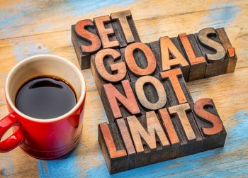 a coffee on a table with the phrase "set goals not limits"