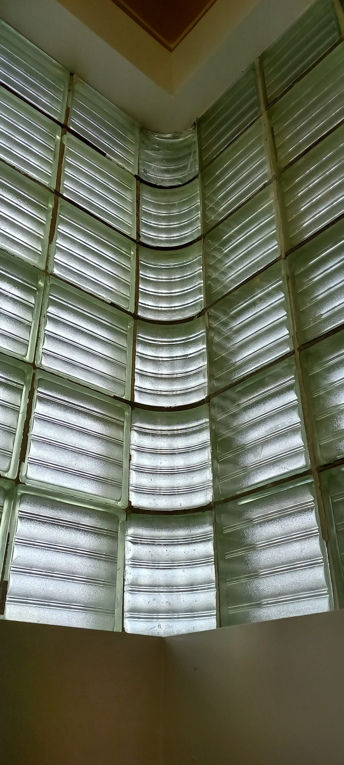 Checkered glass tiles set in the corner of the building, photographed from the inside.