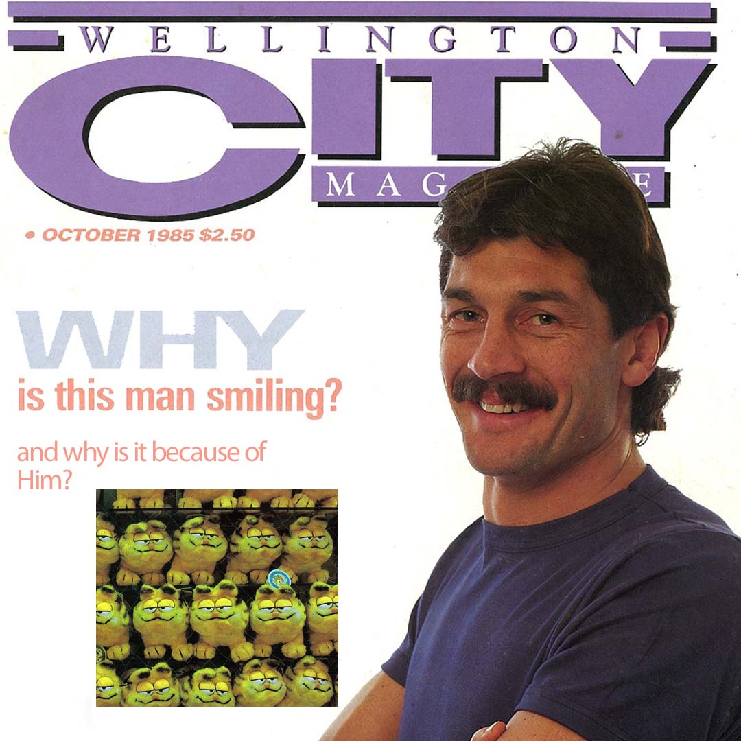 A man stands proud on the cover of Wellington City Magazine, with the found caption "Why is this man smiling". Alayne has photoshopped a picture of a bunch of Garfield toys with the answer "and why is it because of him?".